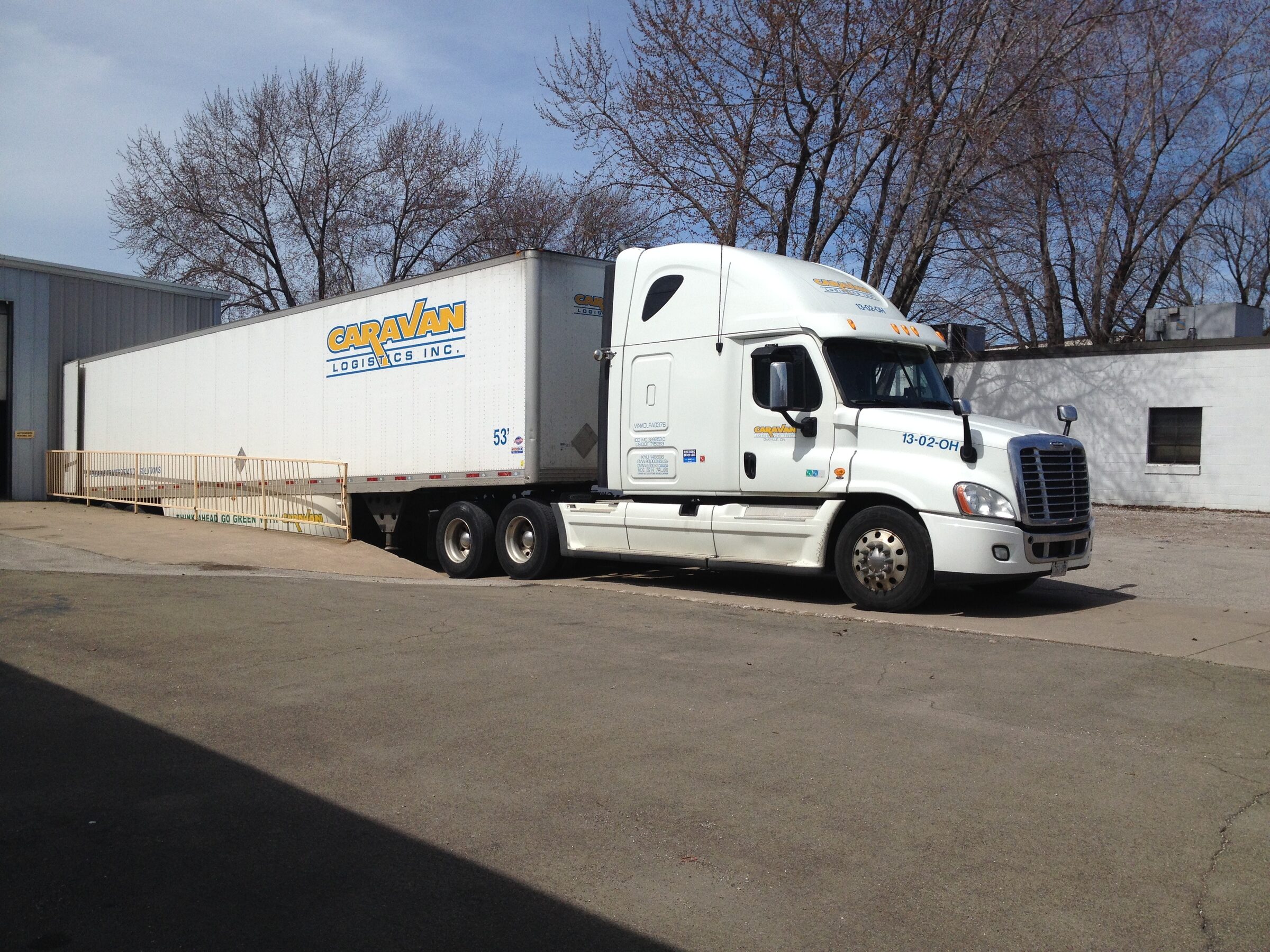 White Caravan rig backed into a warehouse loading dock
